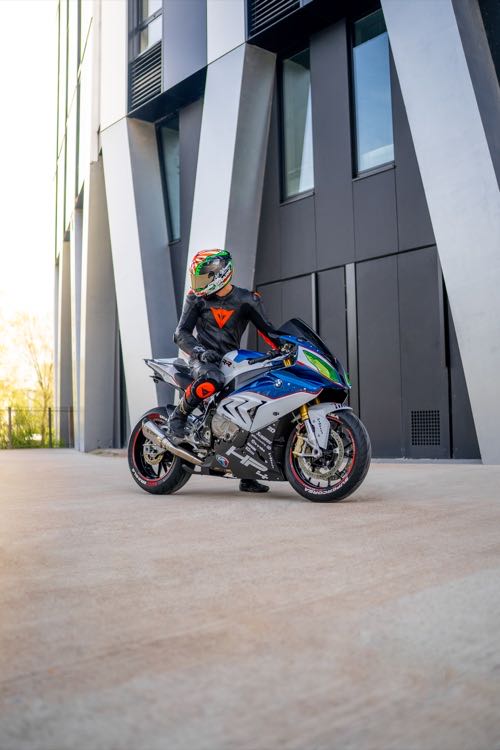 Moto sportive à l'arrêt devant la façade anguleuse d'un immeuble contemporain