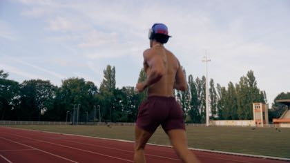 Le coureur de dos sur la piste, casquette bleue
